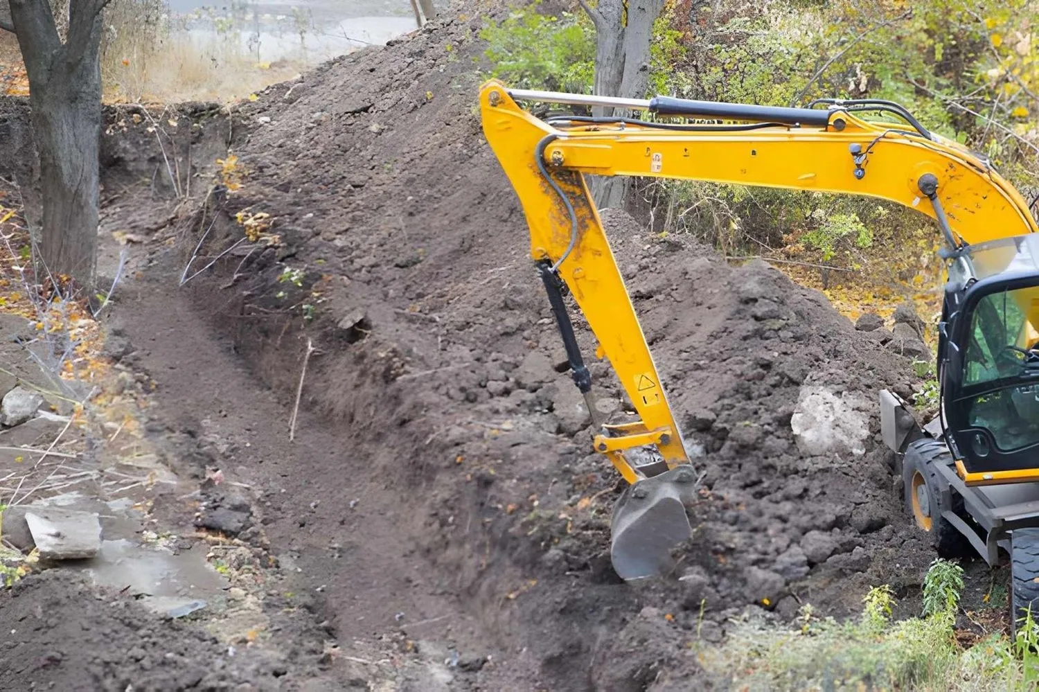 A bulldozer is loading dirt into a bucket at a construction site.